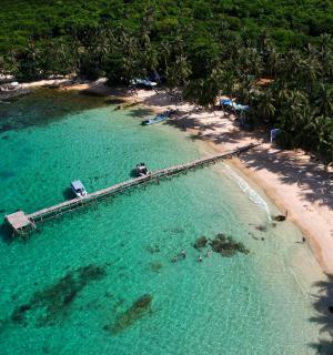 an aerial view of a beach with a boat in the water