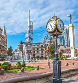 a clock on a pole in the middle of a city