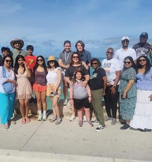 a group of people posing for a picture by the water