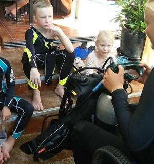 一名女子正在给骑摩托车的两个孩子拍照