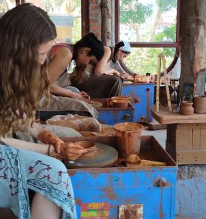 sekumpulan wanita duduk mengelilingi meja membuat tembikar