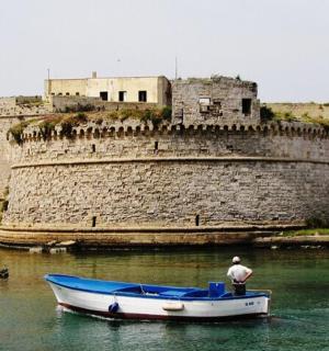 a man in a boat in the water in front of a castle