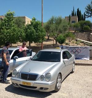 two men standing next to a white car