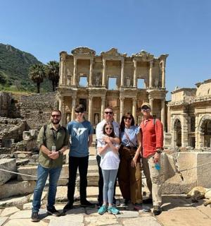 a group of people standing in front of the ruins