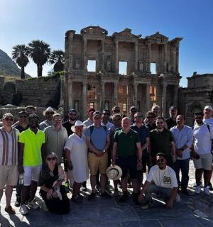 a group of people posing in front of the ruins