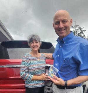 a man and a woman standing next to a car