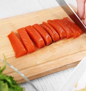 a person cutting carrots on a cutting board with a knife