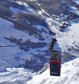 ein Skilift, der einen schneebedeckten Berg hinauffährt