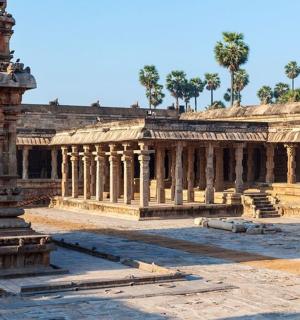 一座巨大的石头建筑，背景是柱子和树木