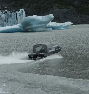 a boat in the water next to an iceberg