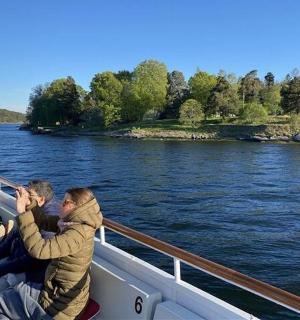 three people sitting on a boat on the water