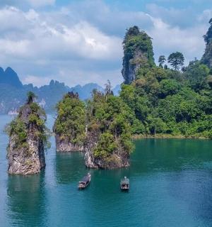a group of boats in a body of water with mountains