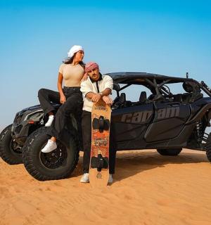 沙漠中，一男一女站在一辆汽车旁