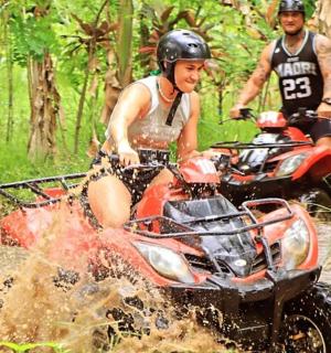 两个人骑着四轮车在泥地里