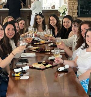 a group of people sitting around a table drinking wine