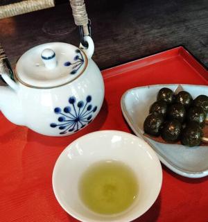 a red tray with a tea pot and a bowl of dates