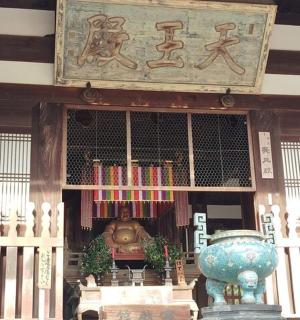 a temple with a statue in the front of a building