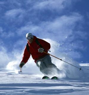 一名男子正在从积雪覆盖的斜坡上滑雪下来