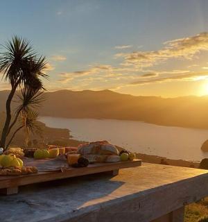 一张摆满水果和蔬菜的桌子,放在窗台上,欣赏日落