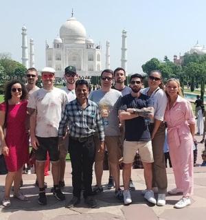 a group of people posing in front of the taj mahal