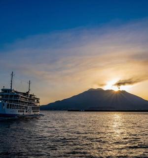 a cruise ship in the water with a mountain in the background