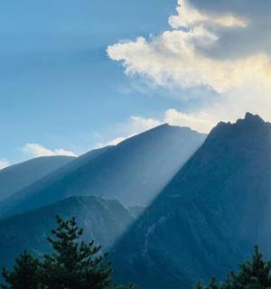 a view of a mountain range with trees in the foreground