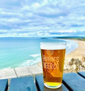 坐在海滩附近的野餐桌上喝一杯啤酒