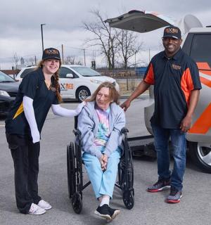 žena na invalidním vozíku vedle muže s dodávkou