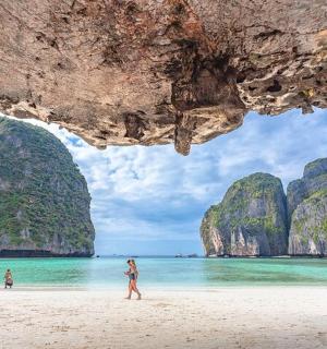 一群人在石灰岩悬崖的海滩上散步