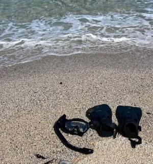 a pair of goggles and sunglasses on the beach
