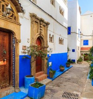 ulička s modrými a bílými budovami a dřevěnými dveřmi