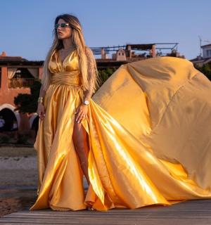 一位身穿黄色连衣裙的女士站在码头上