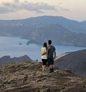 a man and woman standing on top of a mountain