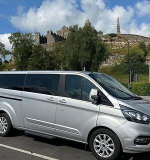 一辆银色货车停在停车场,背景是一座城堡