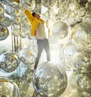 a man standing in front of a wall of balls
