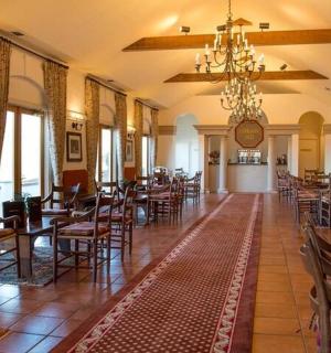 jídelna se stoly, židlemi a lustrem