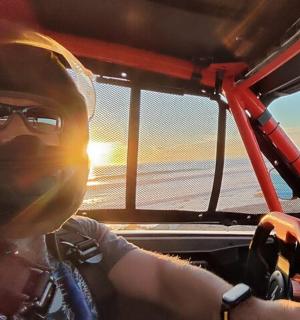 a woman driving a boat on the beach