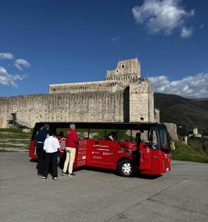 一群人站在一辆红色巴士外面