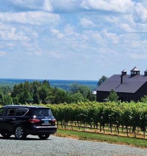 černé auto zaparkované na silnici před stodolou