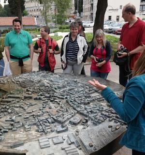 一群人围着一张桌子，桌上放着一个金属拼图