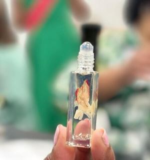 a person holding a small bottle with a painting on it
