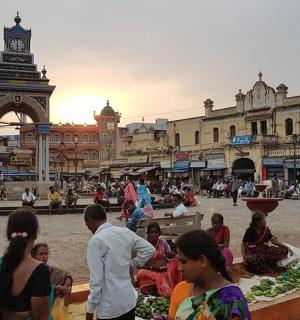 一群人坐在钟楼旁的市场里