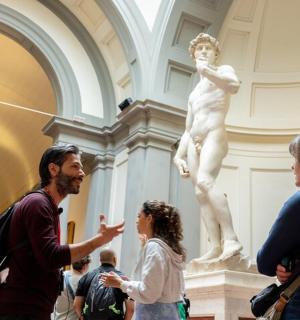 a group of people looking at a statue in a museum