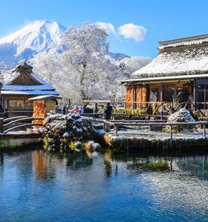 a building and a lake with a snow covered mountain