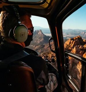 a man wearing headphones sitting in a helicopter