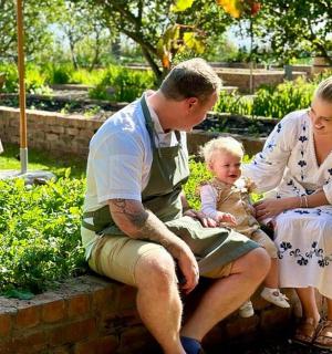 一个男人、一个女人和一个婴儿坐在墙上