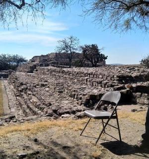 一位戴着帽子的男人站在椅子旁边