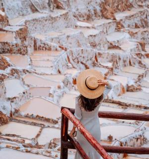 žena sedící na zábradlí a dívající se na zasněženou horu