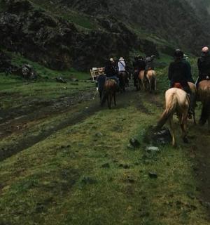a group of people riding horses down a hill