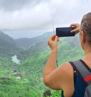 a woman taking a picture of a valley